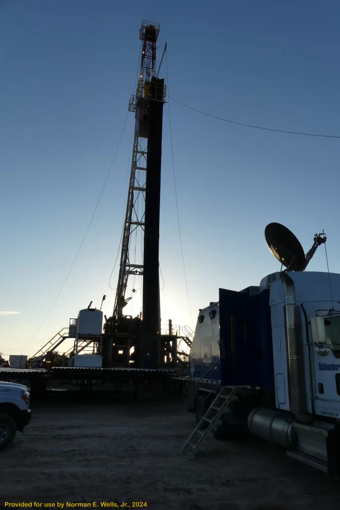 Oil rig with a truck and satellite dish on-site, representing engineering services such as casing and cementing requirements, pressure testing, and geotechnical analysis for onshore well permitting.