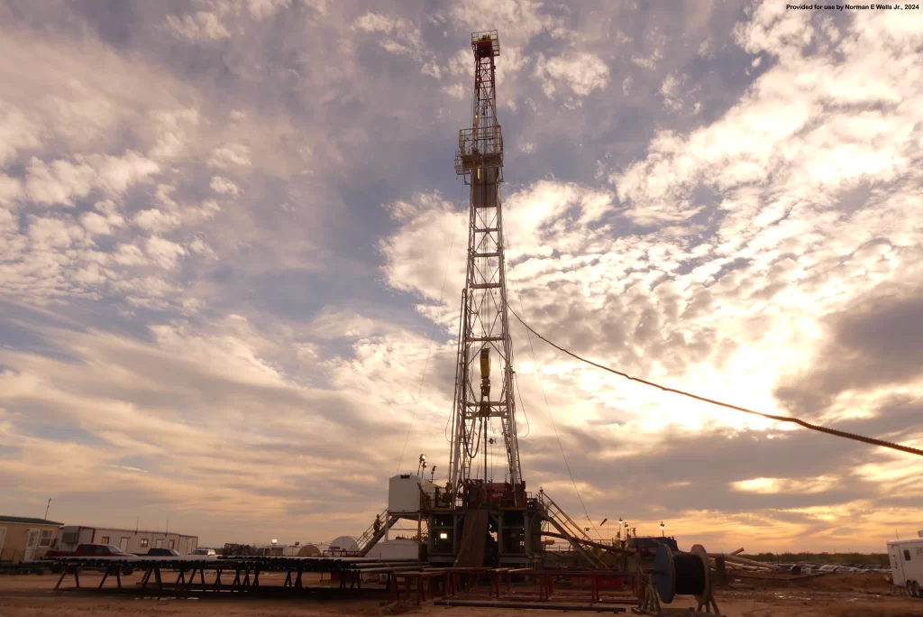 Oil drilling rig set against a cloudy sunset sky in West Texas, illustrating regulatory services including permit application, documentation verification, and communication with regulatory agencies for onshore well permitting.